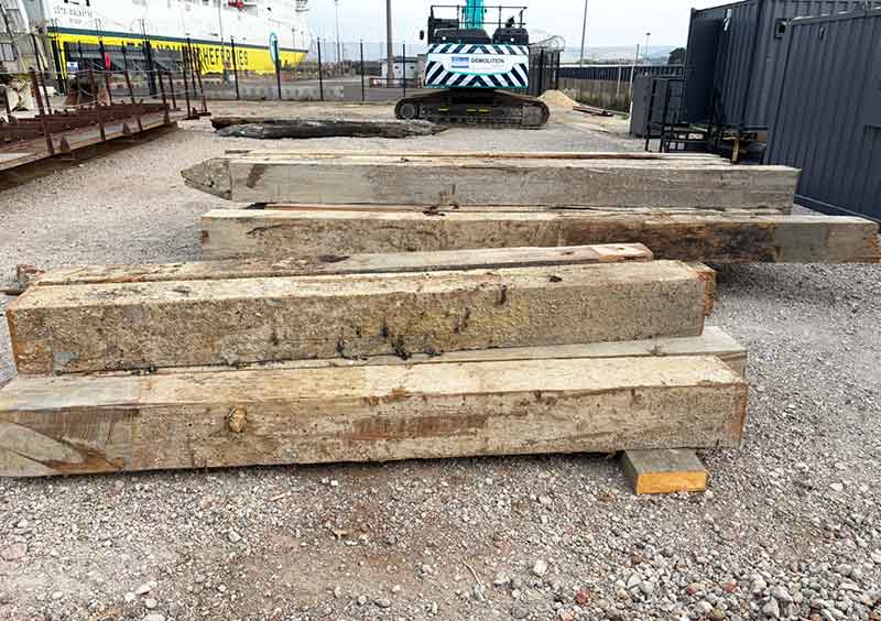 Timbers on the quay with a crane in the background
