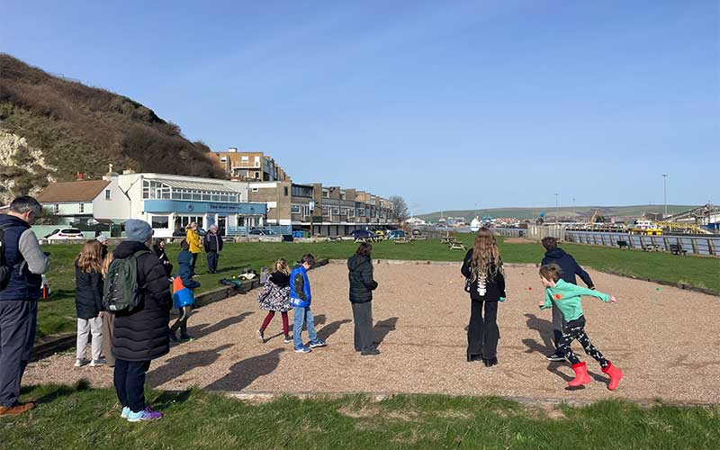 children and adults on the petanque pitch at Newhaven