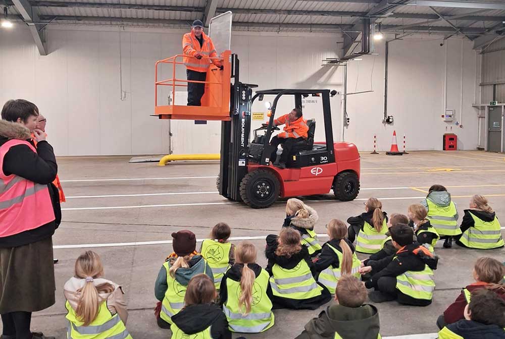 primary school students watching a demonstration at Newhaven Port with a forklift in the background
