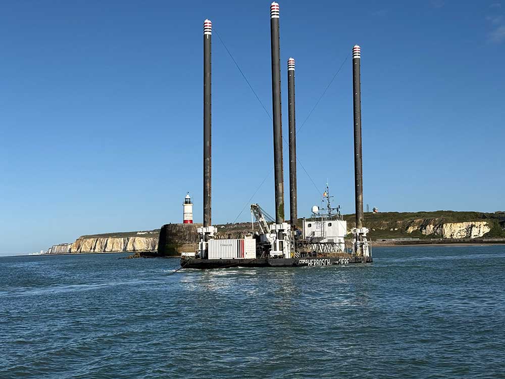 The Herbosch Kiere Octopus platform shown leaving Newhaven Port with the cliffs and lighthouse in the background