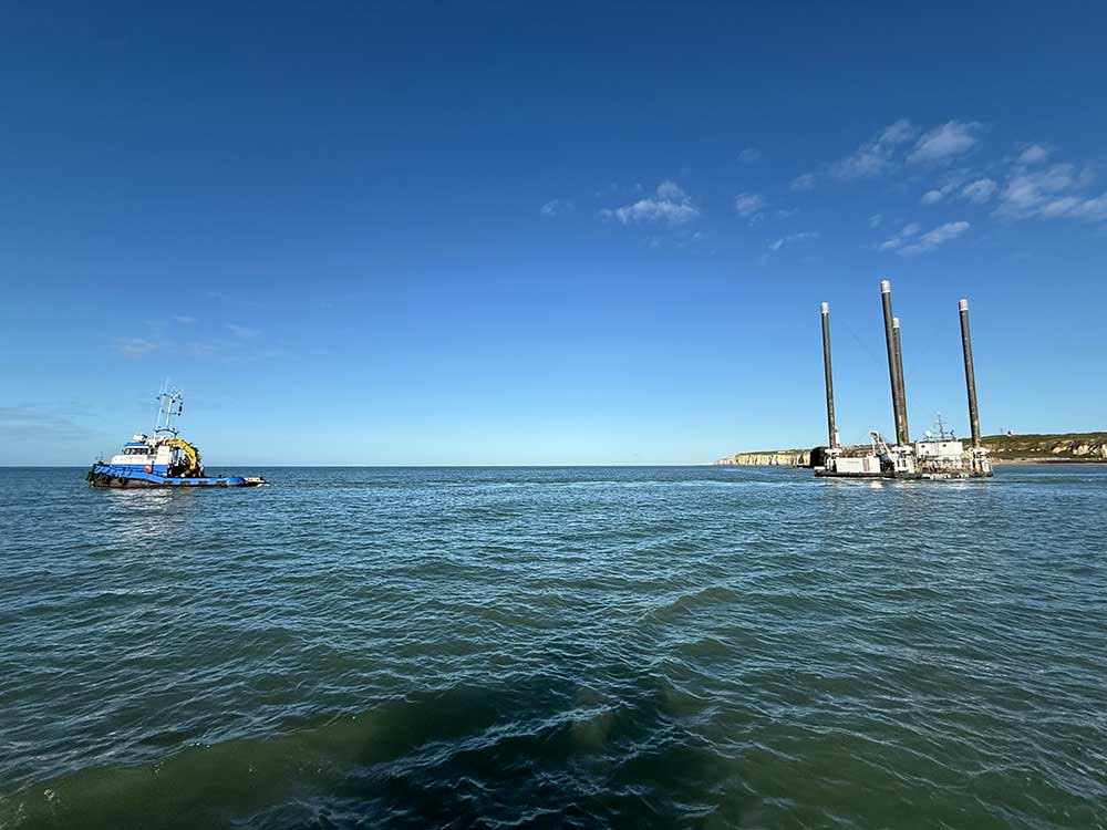 Tug towing the Herbosch Kiere Octopus leaving Newhaven with cliffs in the background