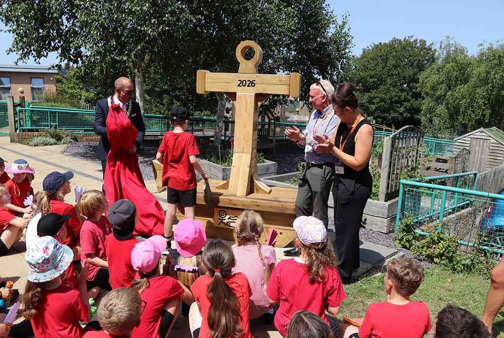 Bench made of ancient port timbers seen with school children at a playground presentation.