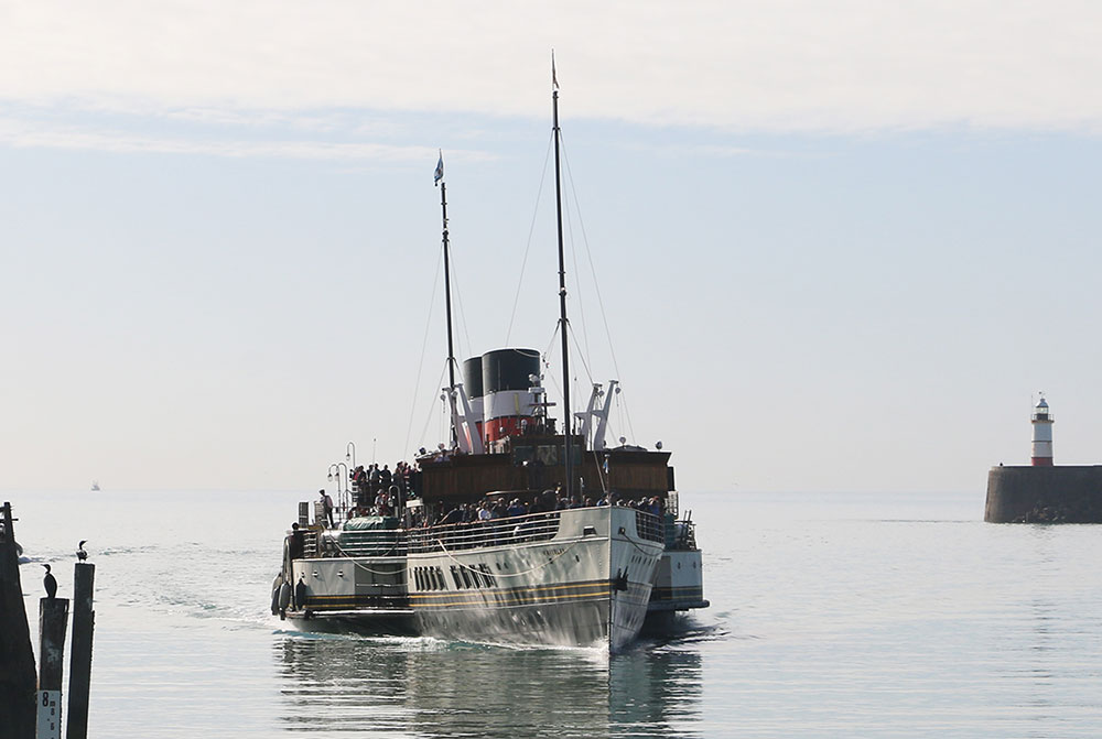 Waverley paddle steamer sailing into Newhaven port between the light house and the east pier