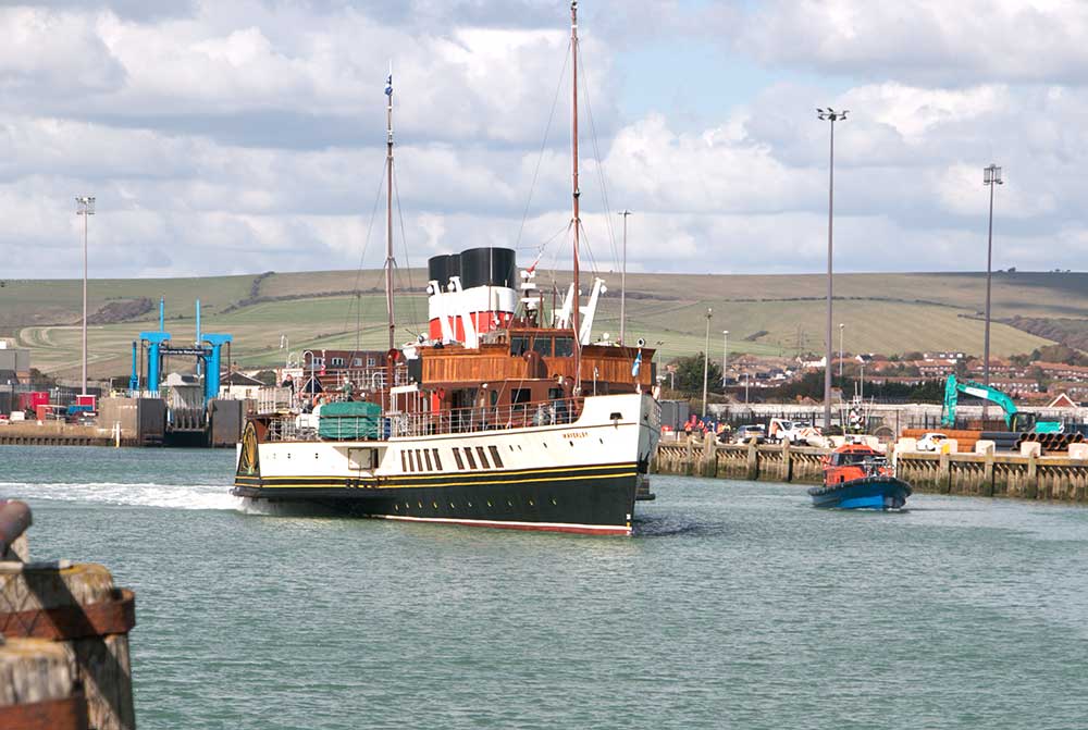 Waverley steamship leaves Newhaven Port with Sussex countryside in the background